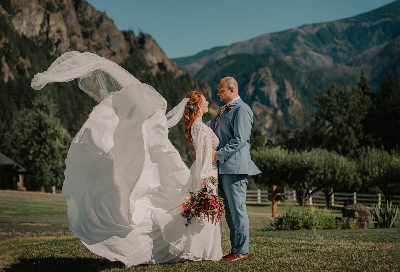 Wedding portrait in the Columbia River Gorge with dramatic cliffs, wind, and natural light.