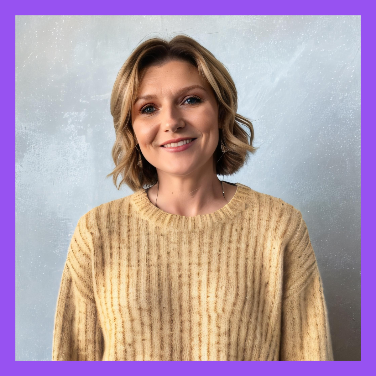A woman with shoulder-length blonde hair smiling, wearing a beige ribbed sweater, standing against a textured gray background with purple borders.