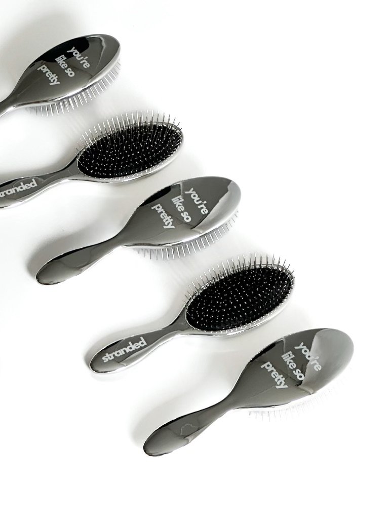Set of five Stranded Studios detangling brushes for hair extensions, styled for salon use in Phoenix