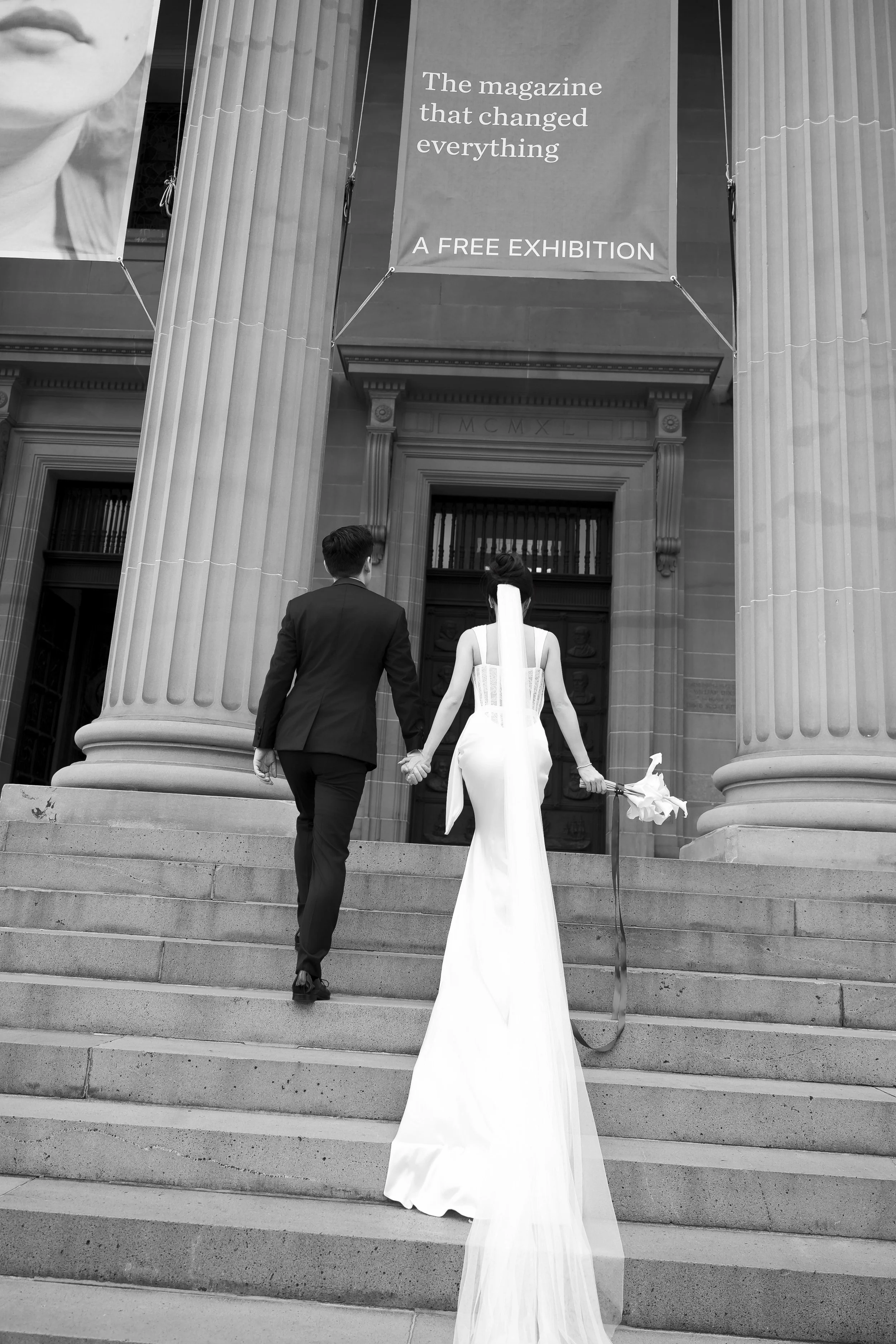 Bride and groom walking up the steps of the Art Gallery of New South Wales, captured by a Sydney wedding photographer in an elegant editorial style.