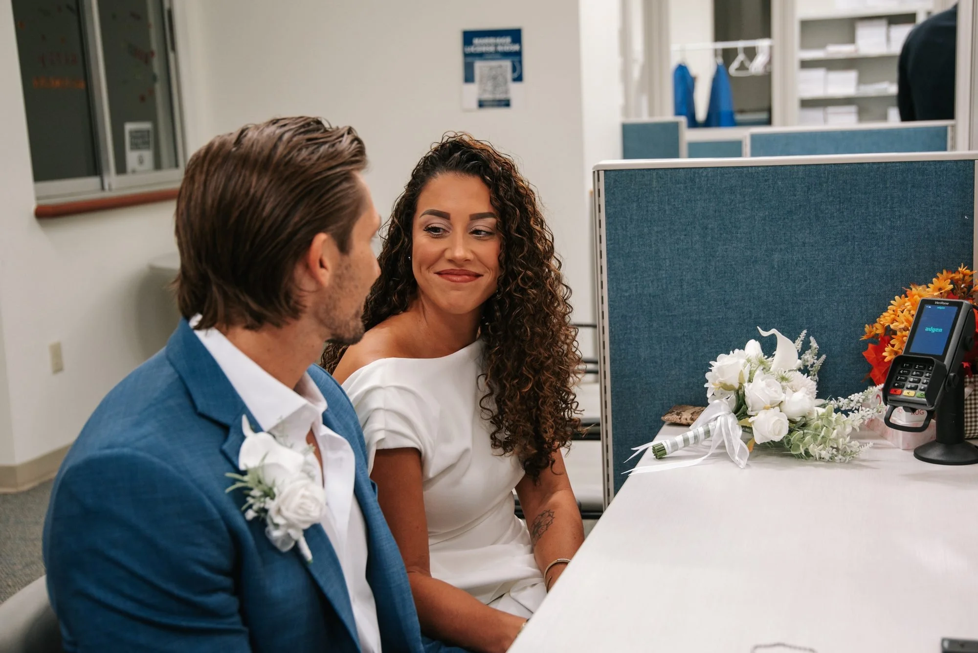 Couple smiling at each other while waiting at the marriage license counter in Delray Beach