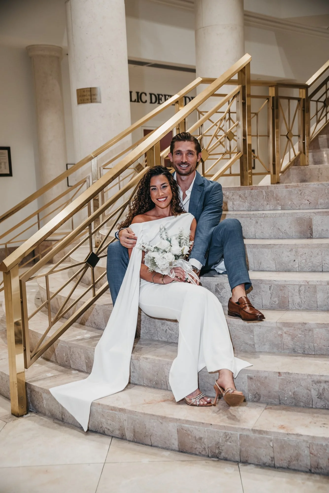 Newlyweds sitting together on the courthouse staircase in Delray Beach