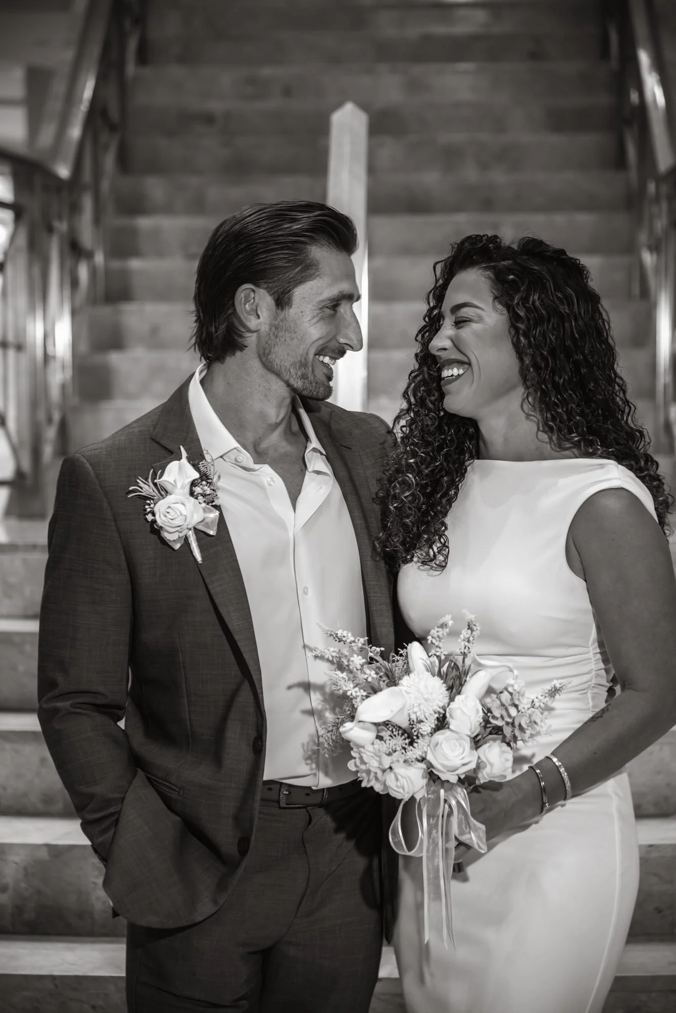 Black and white portrait of a smiling couple on the Delray Beach courthouse stairs