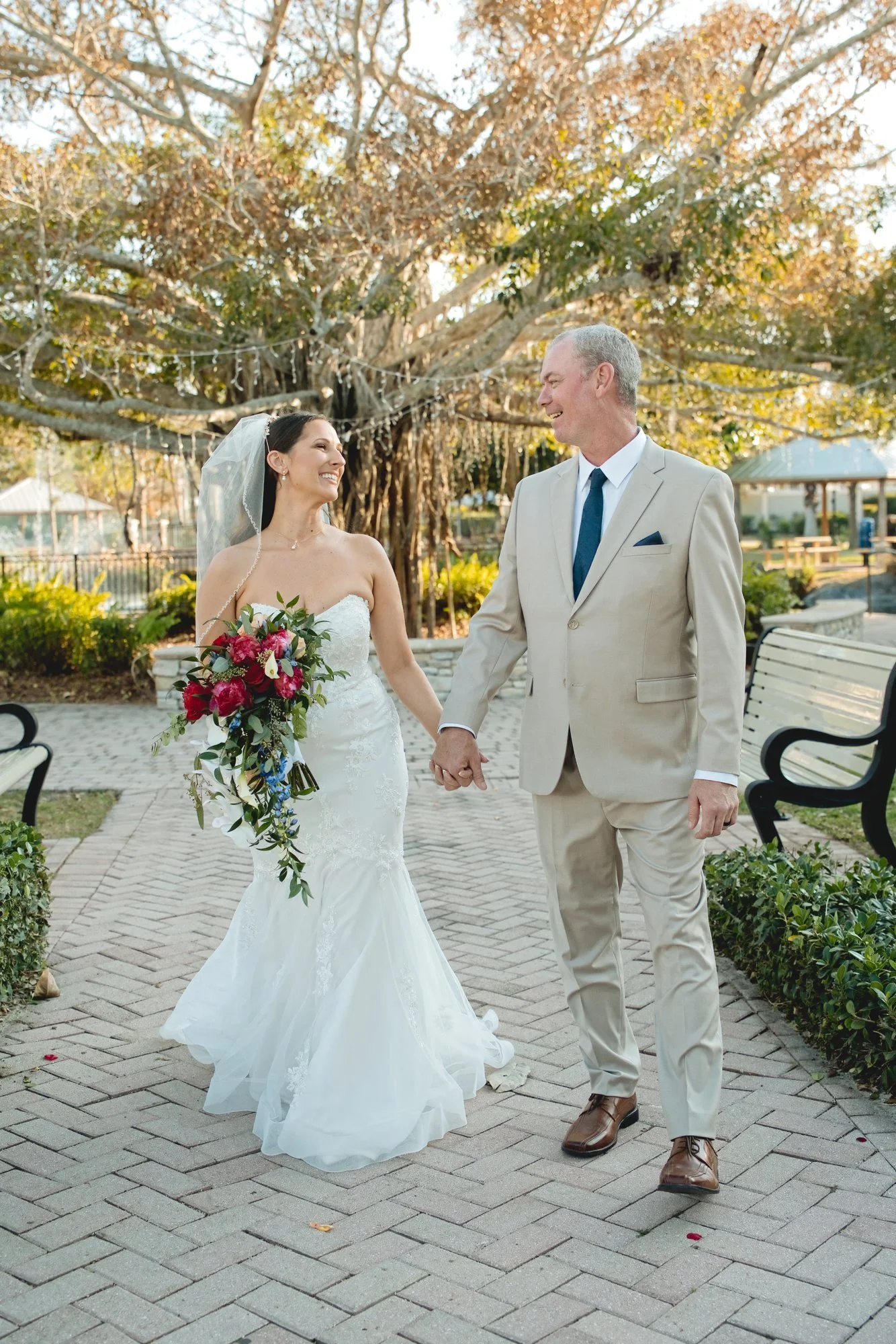 Newlyweds holding hands on the brick path at Memorial Park in Stuart, Florida