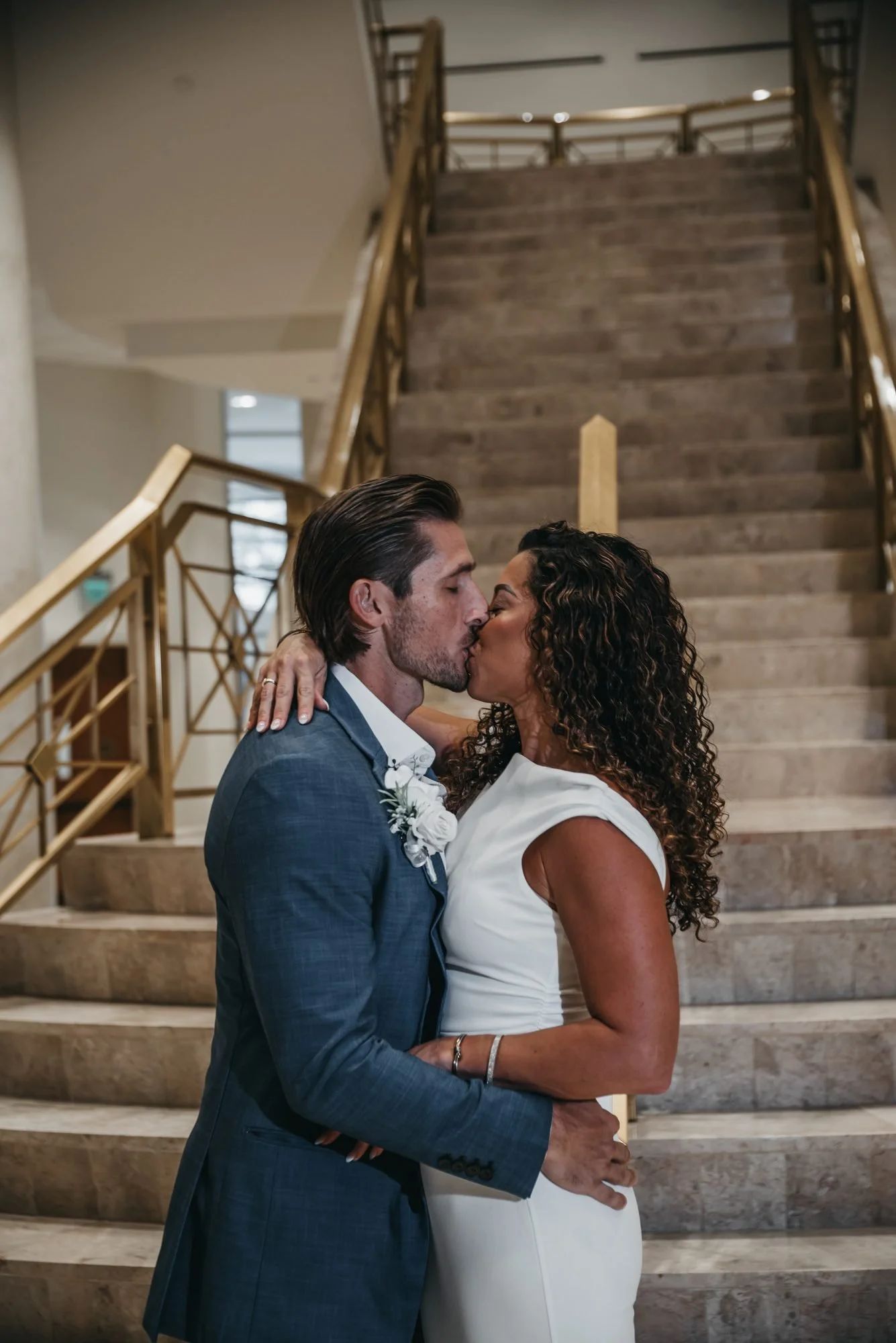 Couple's first kiss as newlyweds on the courthouse staircase in Delray Beach