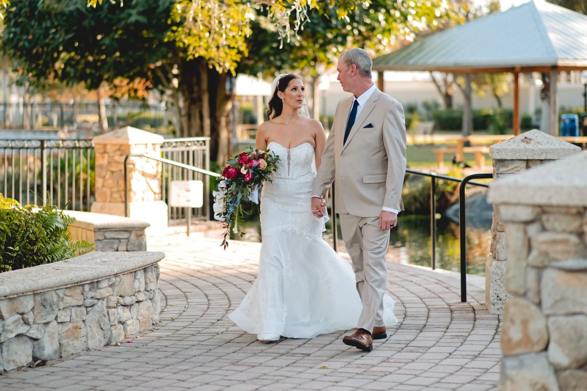 Bride and groom walking together on the stone path at Memorial Park in Stuart