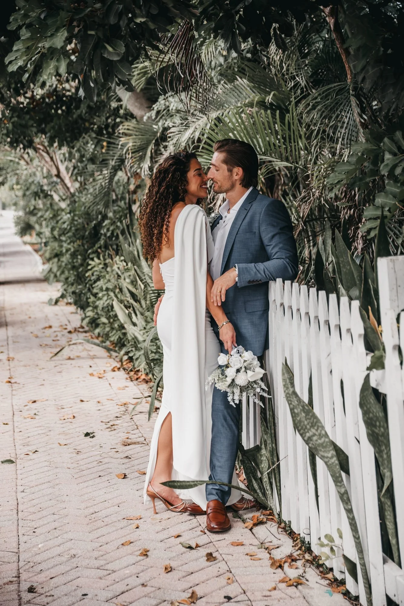 Couple sharing a quiet moment beside a white picket fence at Old School Square in Delray Beach