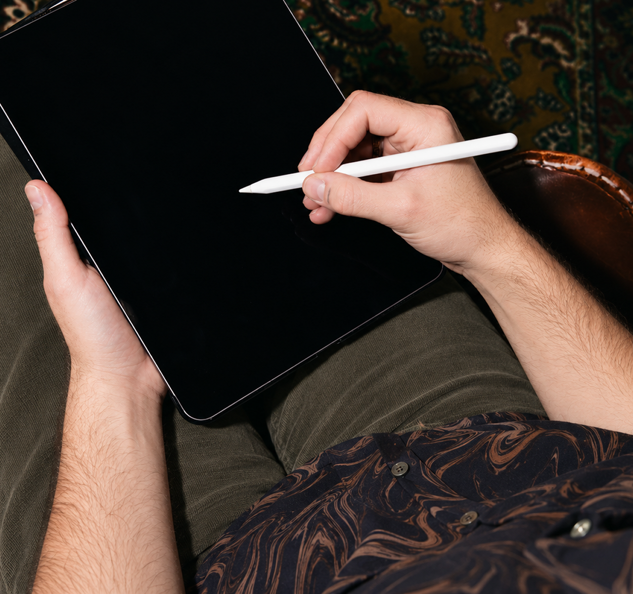 Person holding a tablet in one hand and using a white stylus with the other hand.