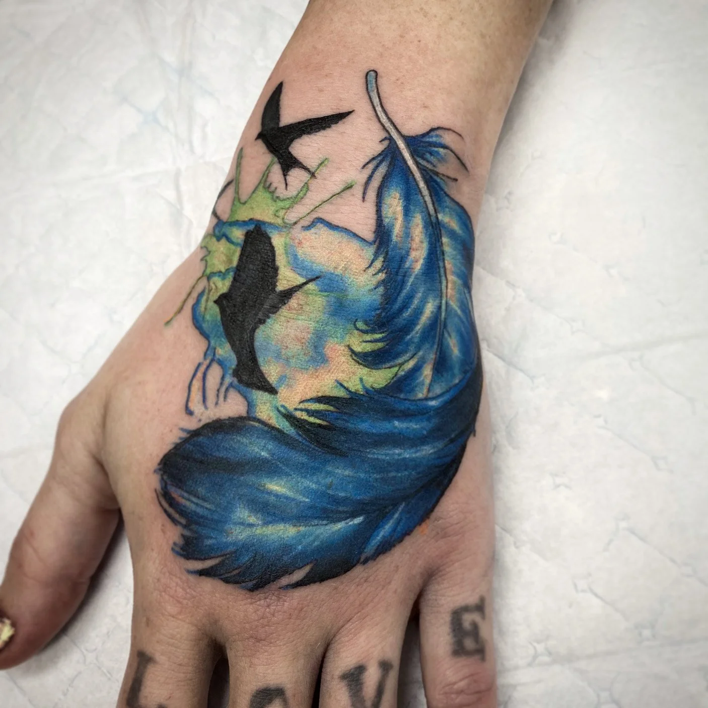 Watercolour feather hand tattoo brisbane pop culture gaming tattooos