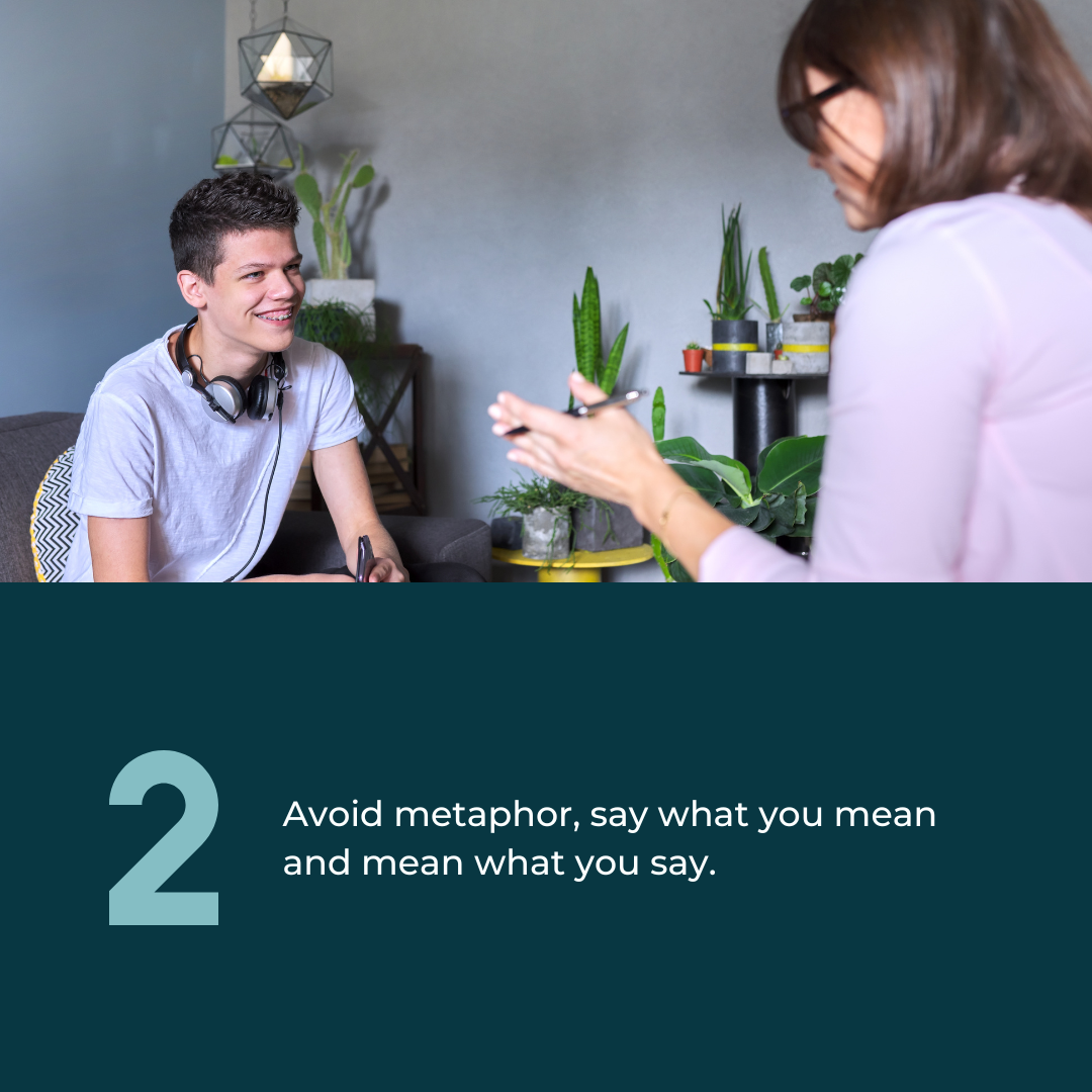  2: Avoid metaphor, say what you mean and mean what you say. Photo of a White teenage boy being spoken to by an adult. He's smiling and wearing headphones around his neck. 