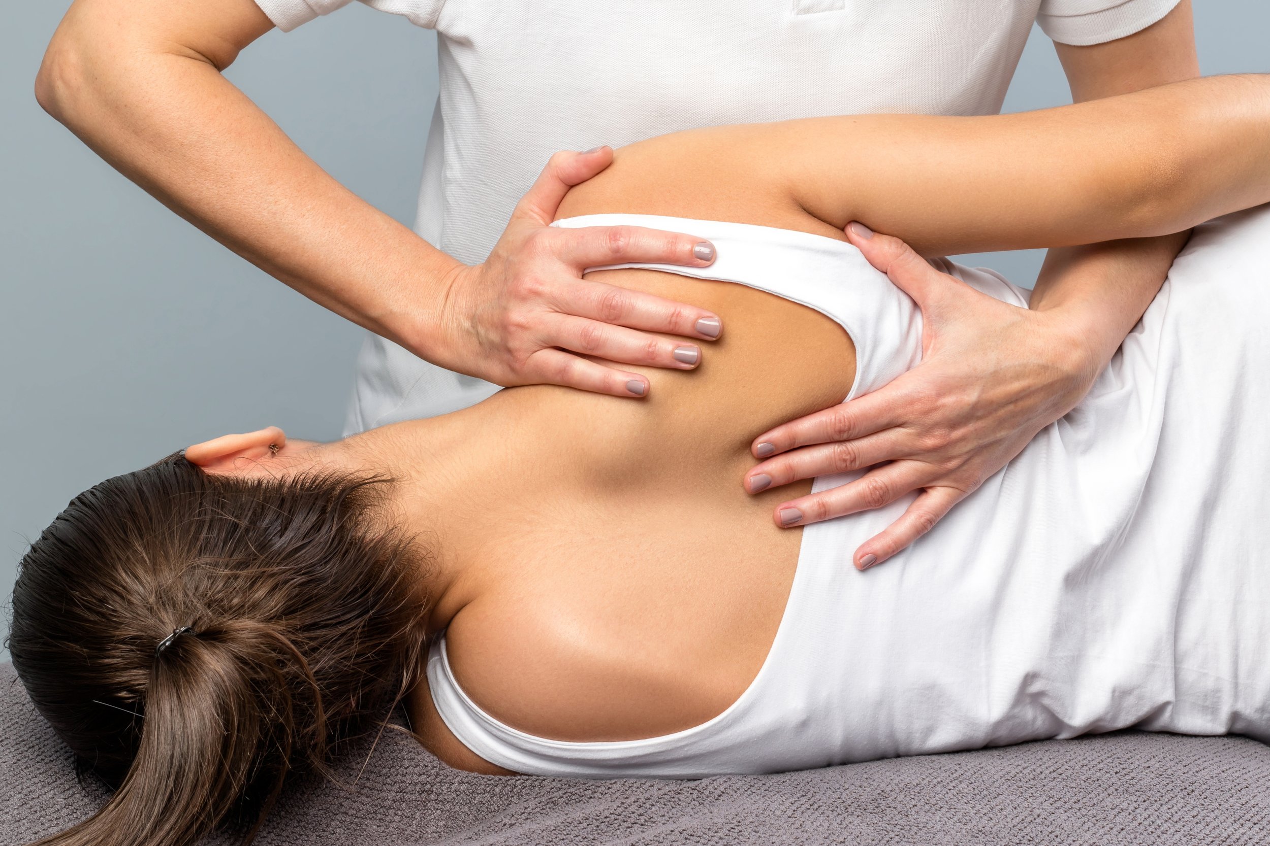 A woman chiropractor providing a manual adjustment to a female patient