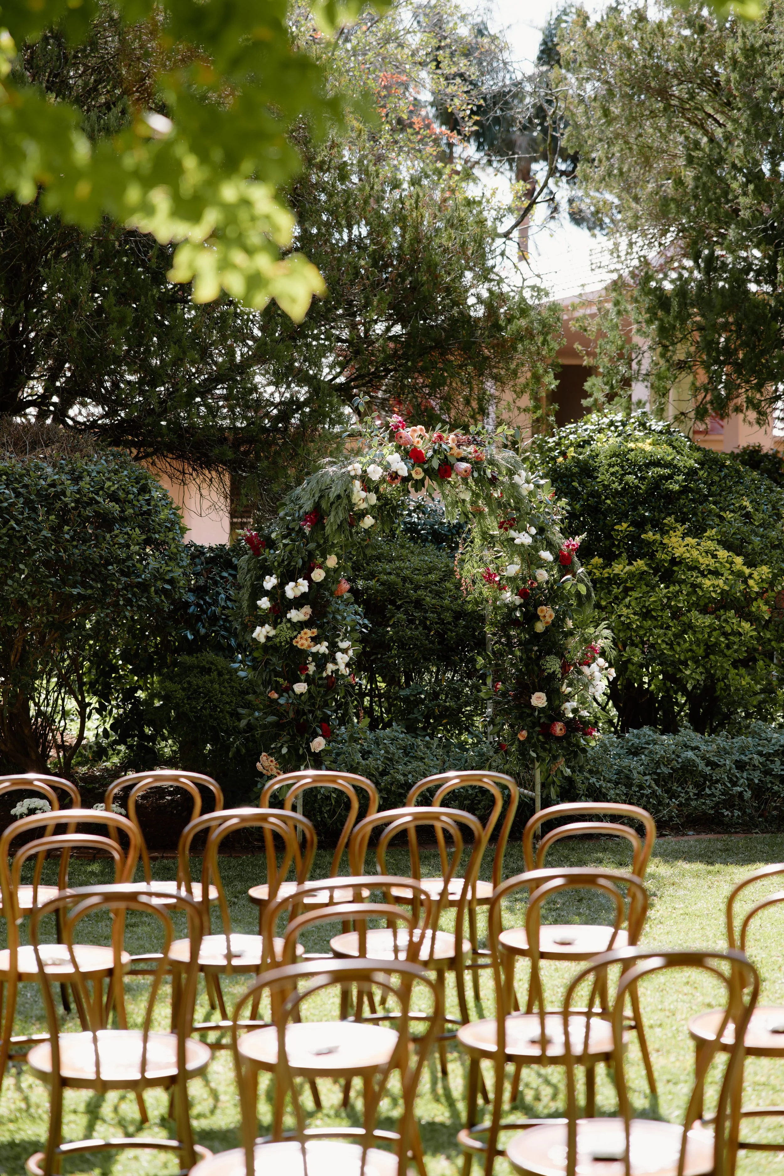 Outdoor garden ceremony with a floral arch.