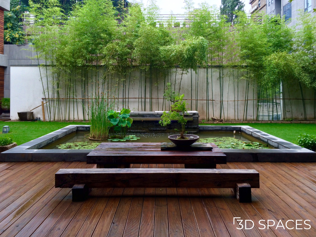 Modern courtyard landscape design with bamboo garden, koi pond, wooden deck, and Zen-inspired outdoor seating area.