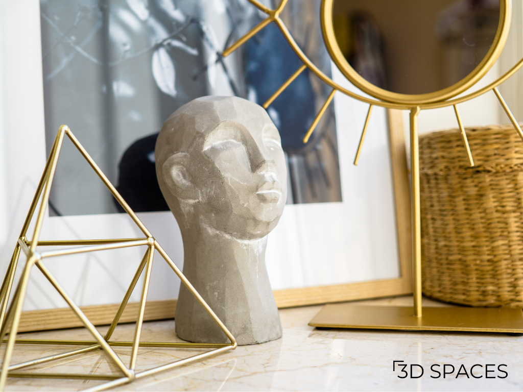 Modern home décor accessories featuring an abstract sculpture, decorative gold mirror, geometric metal décor, and luxury tabletop styling.