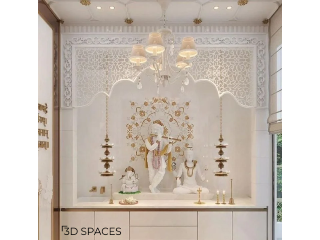 Modern white marble pooja room design with Lord Krishna, Shiva and Ganesha idols, carved wall panels, brass hanging diyas, and elegant home temple decor.