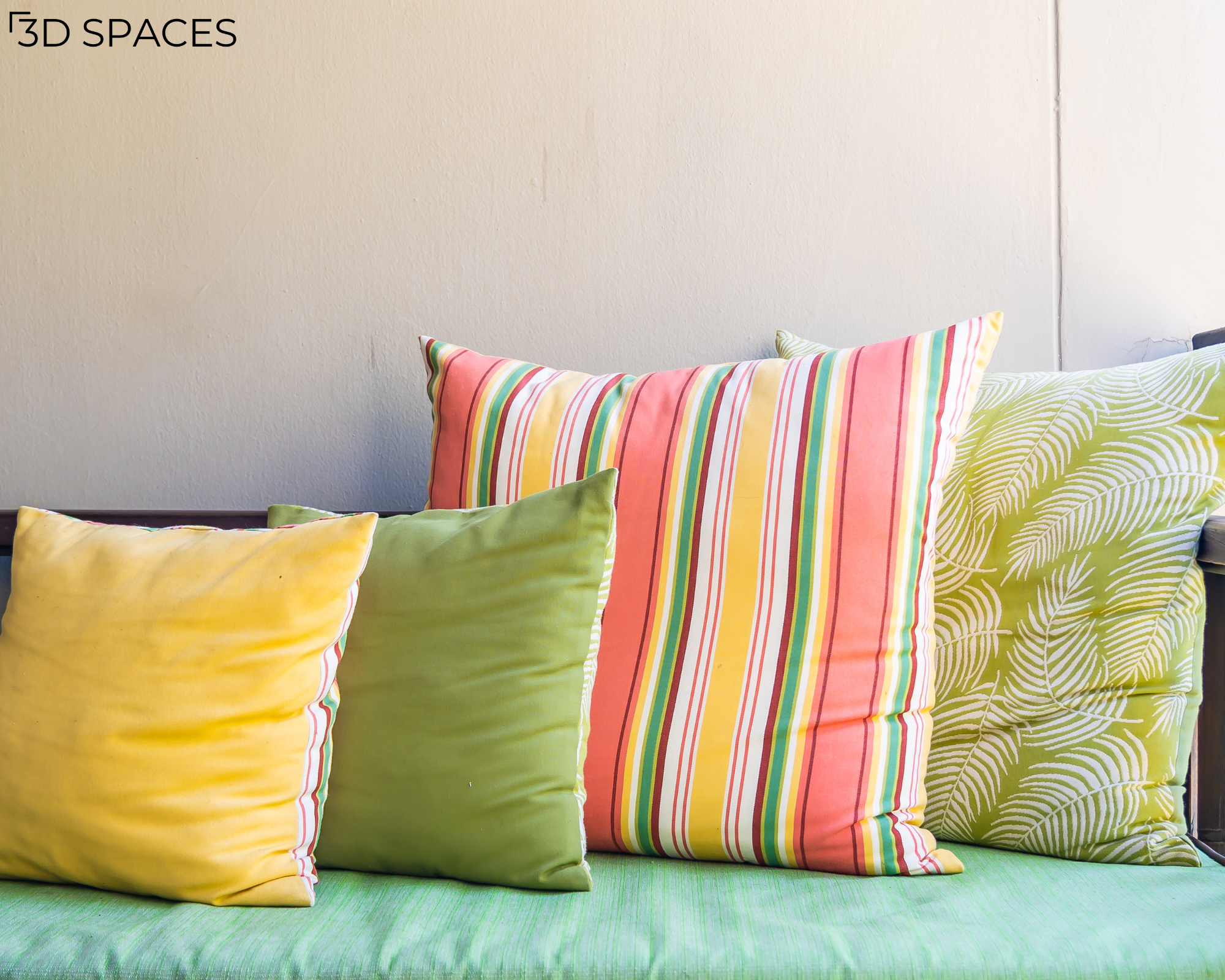 Outdoor patio sofa decorated with colorful throw cushions featuring striped and botanical patterns for a bright and inviting outdoor living space.