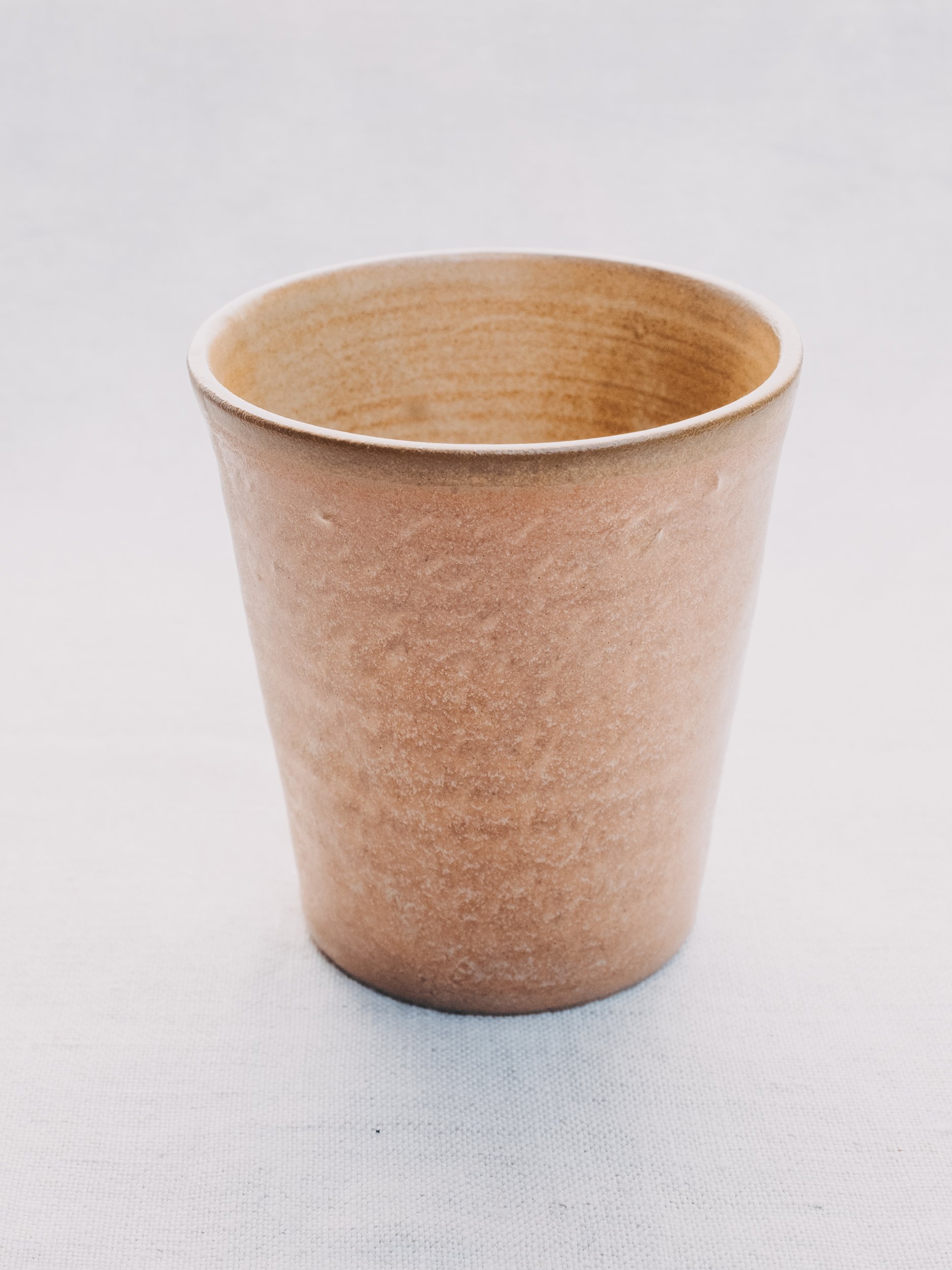 Brown ceramic cup on a light background