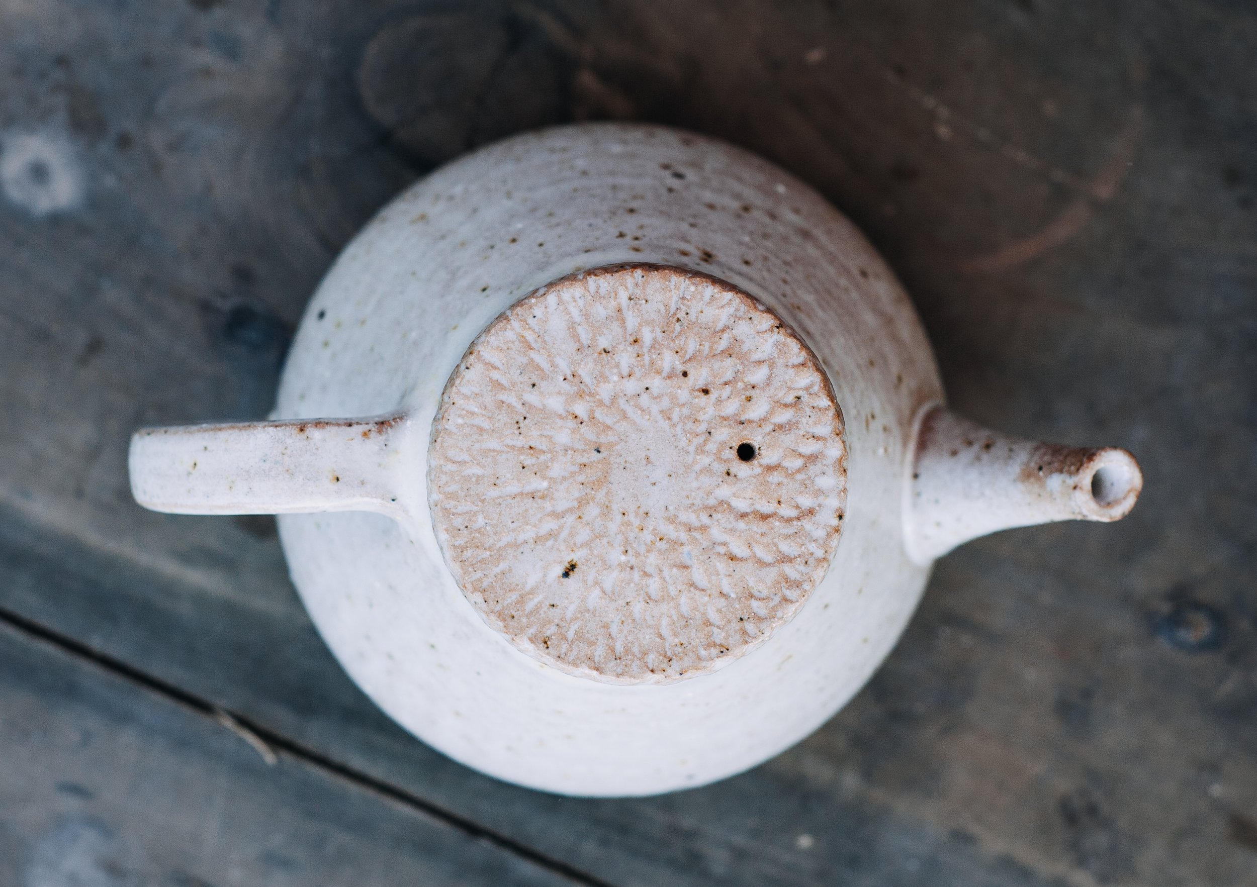 Top view of a ceramic teapot on a wooden surface
