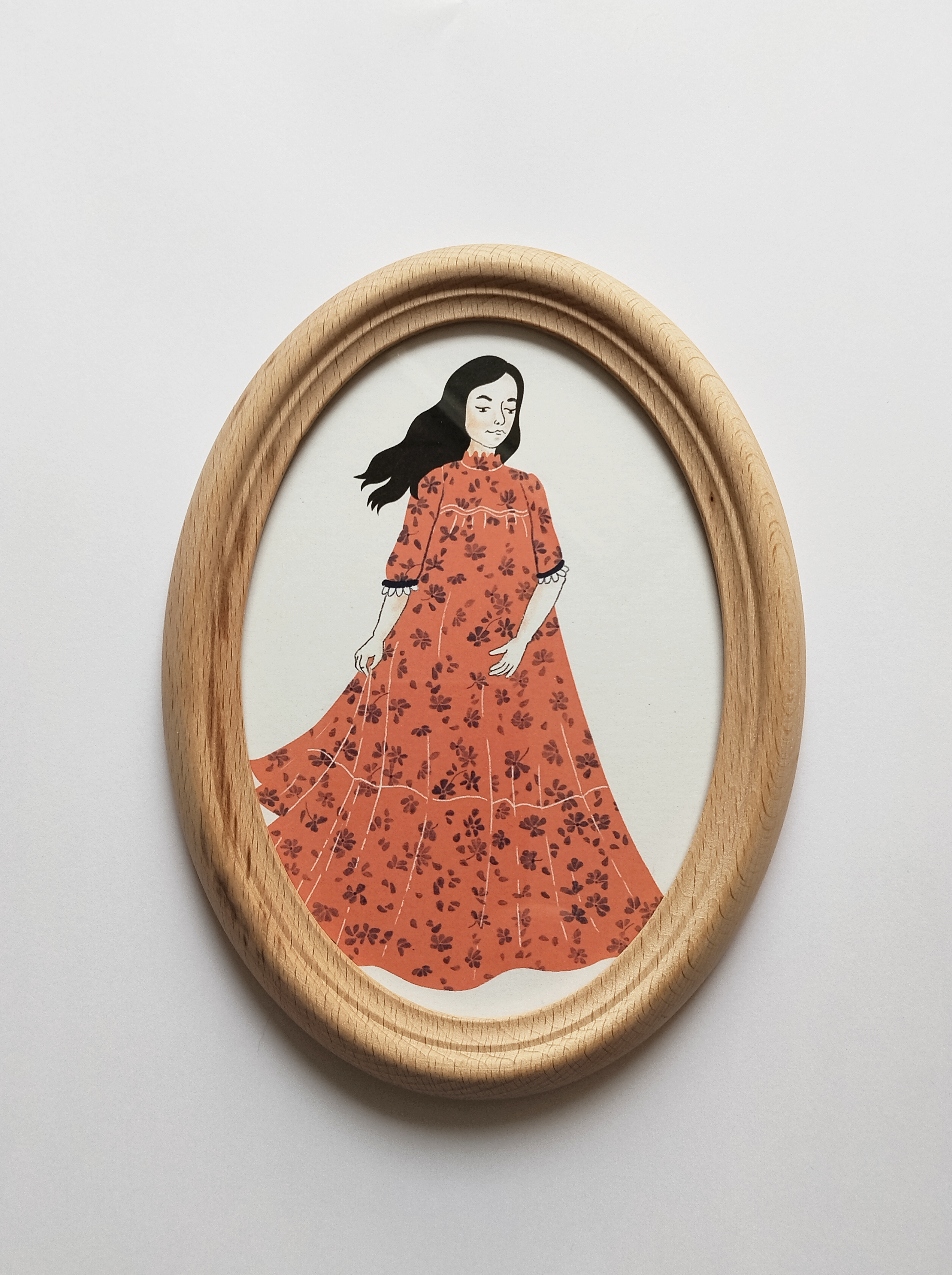 Drobný obrázek v oválném rámu s autorskou ilustrací mladé ženy od ilustrátorky Terezy Paukové.