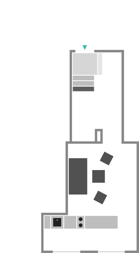Floor plan of a small apartment with an entrance, staircase, kitchen, living area with furniture, and a small bathroom.