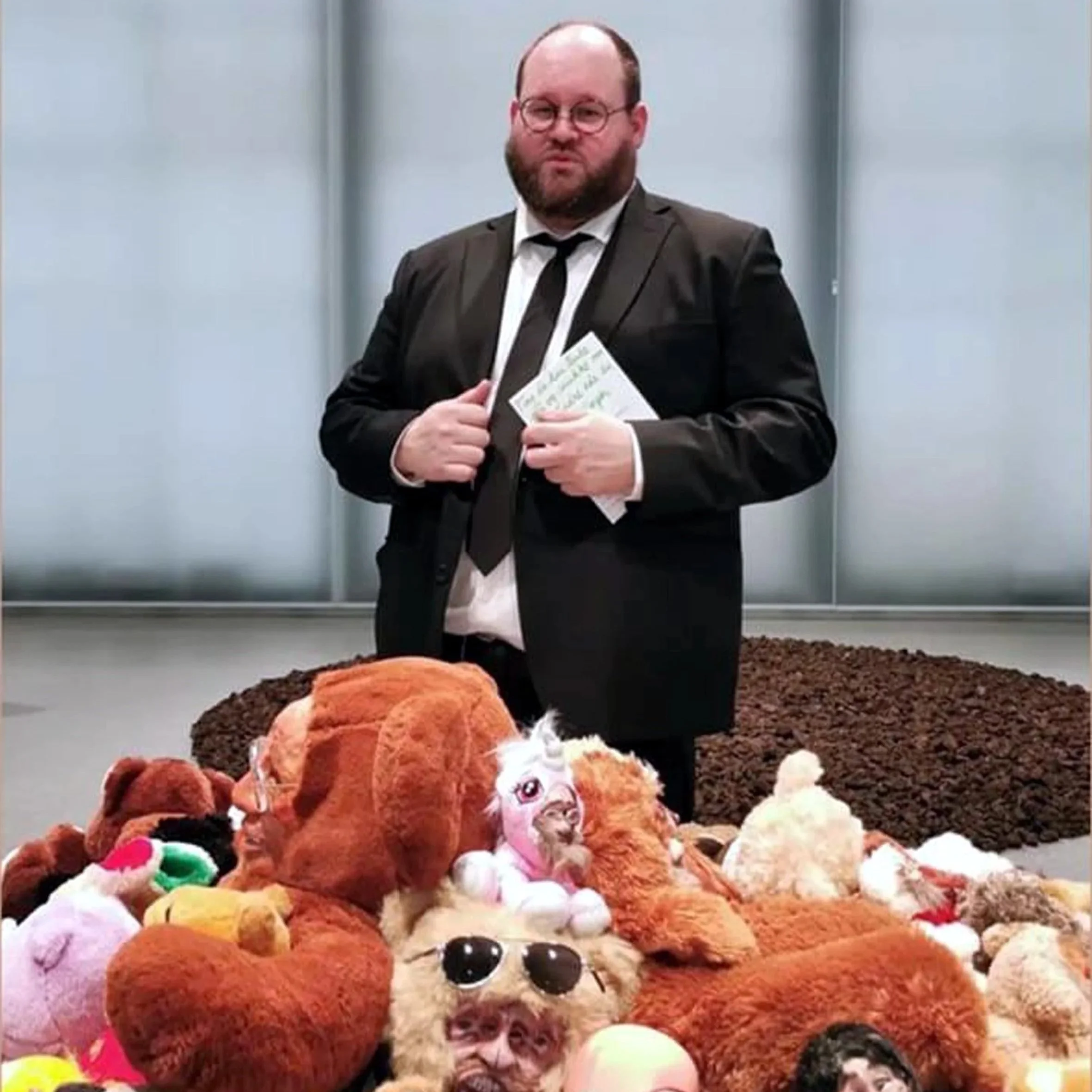 Portrett av Christian Blandhoel bak en samling kosedyr i et galleri.