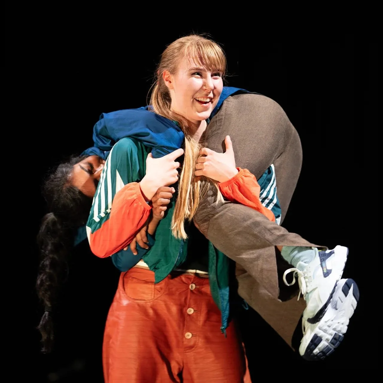 Danser Astrid Serine Hoel på scenen mens hun bærer en annen person. Hun smiler bredt.