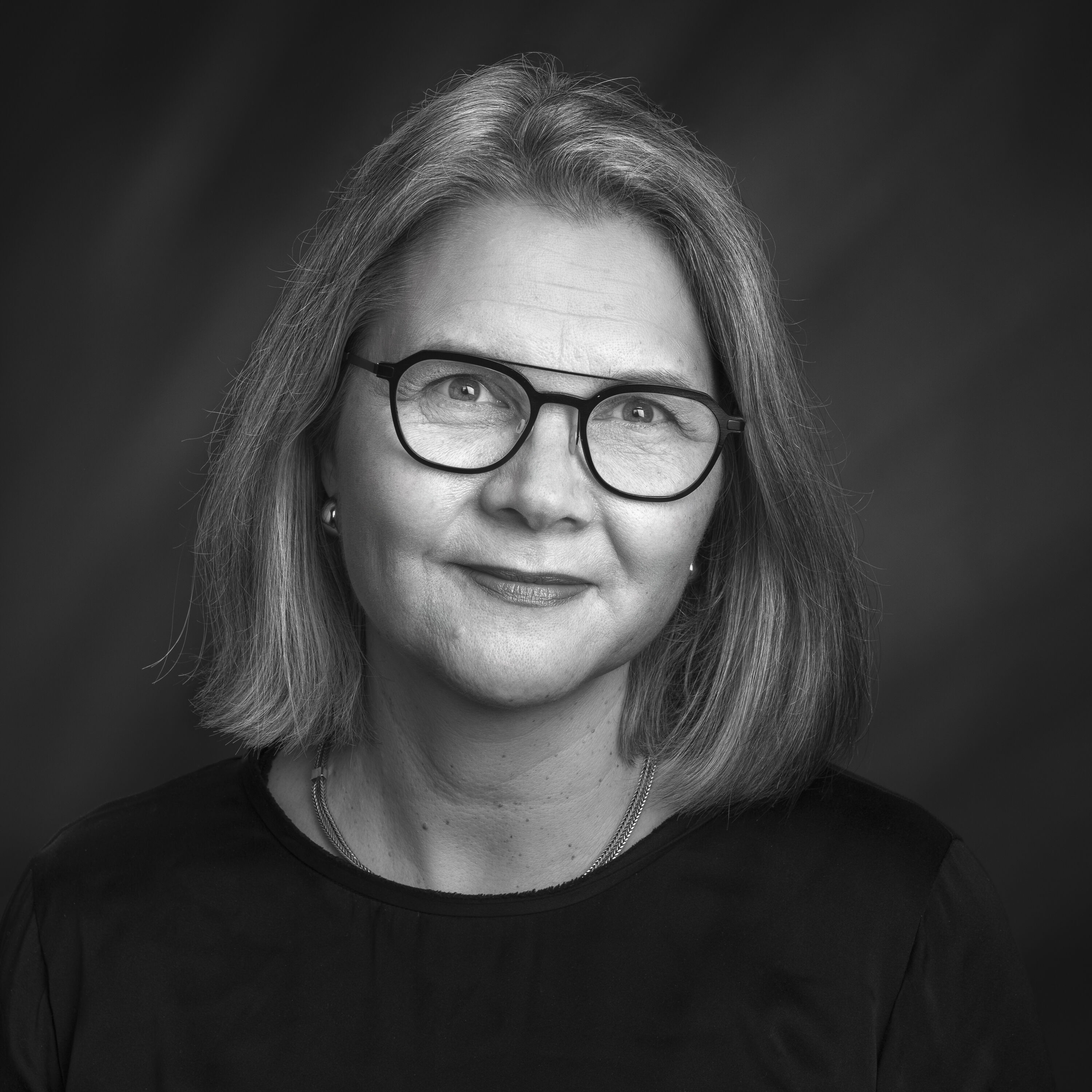 Sort-hvitt portrett av Linda Dyrnes som smiler til kamera