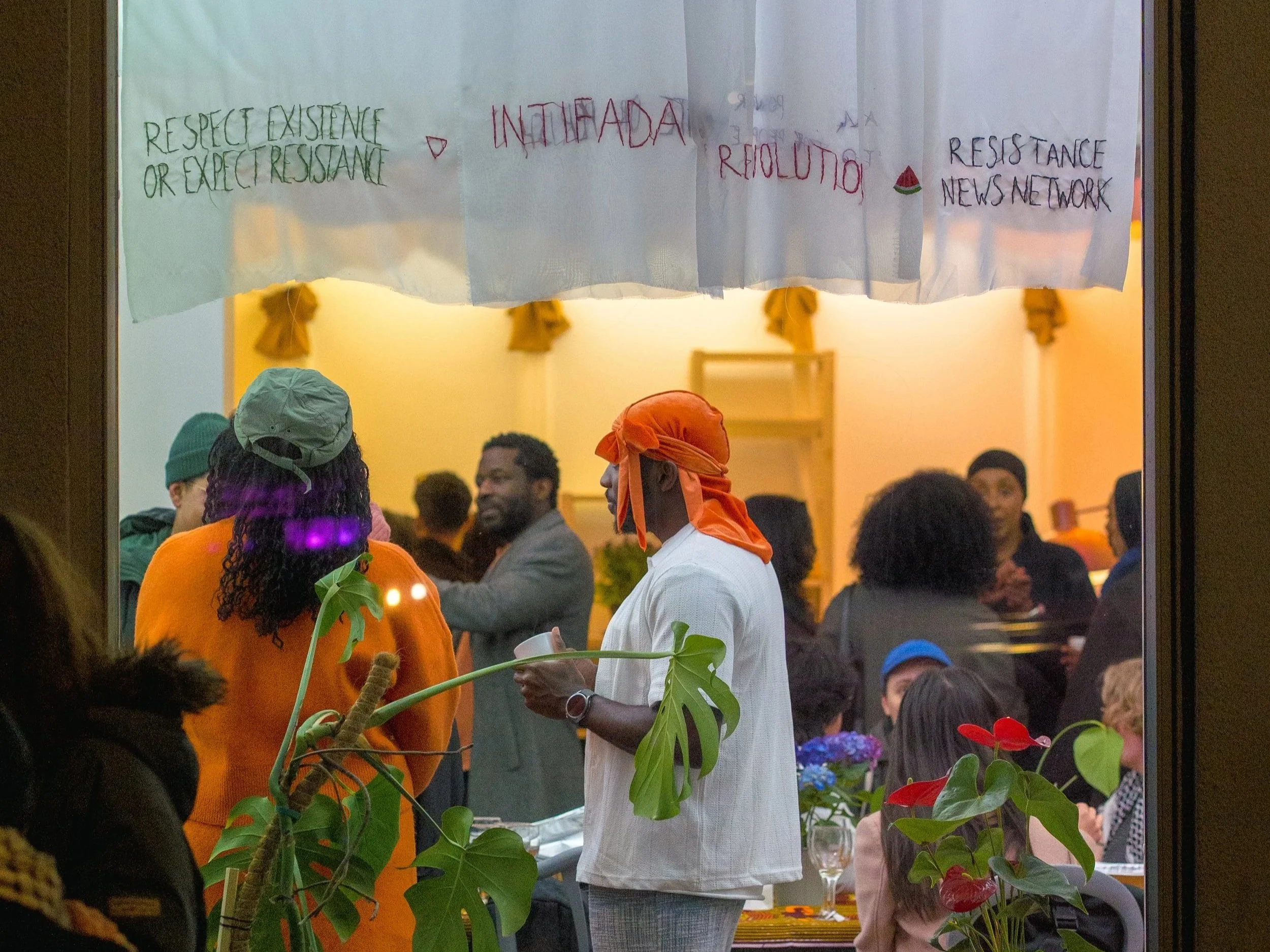 Mennesker som står og snakker sammen avbildet gjennom et stort vindu.