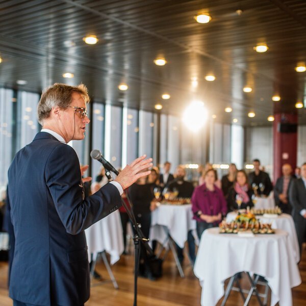 Jørgen Roll prater i mikrofon foran publikum