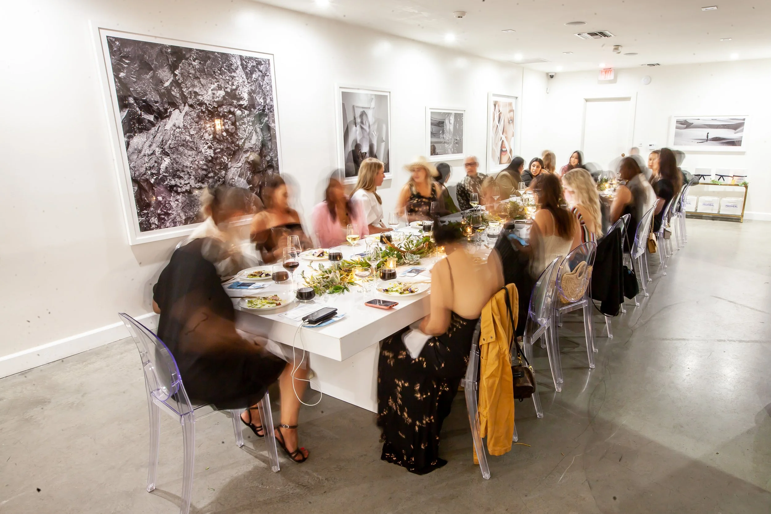 Guests gathered around a communal dining table at the Land Rover Defender Tour rooftop dinner event