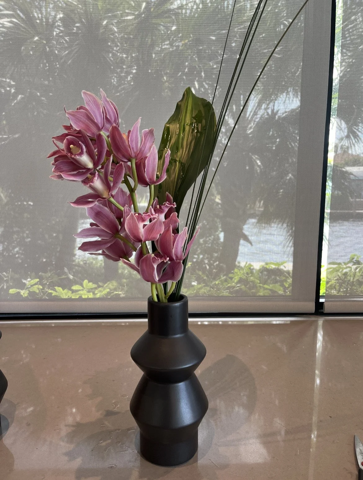 Styled floral centerpiece in a black vase as part of the Land Rover Defender Tour event decor
