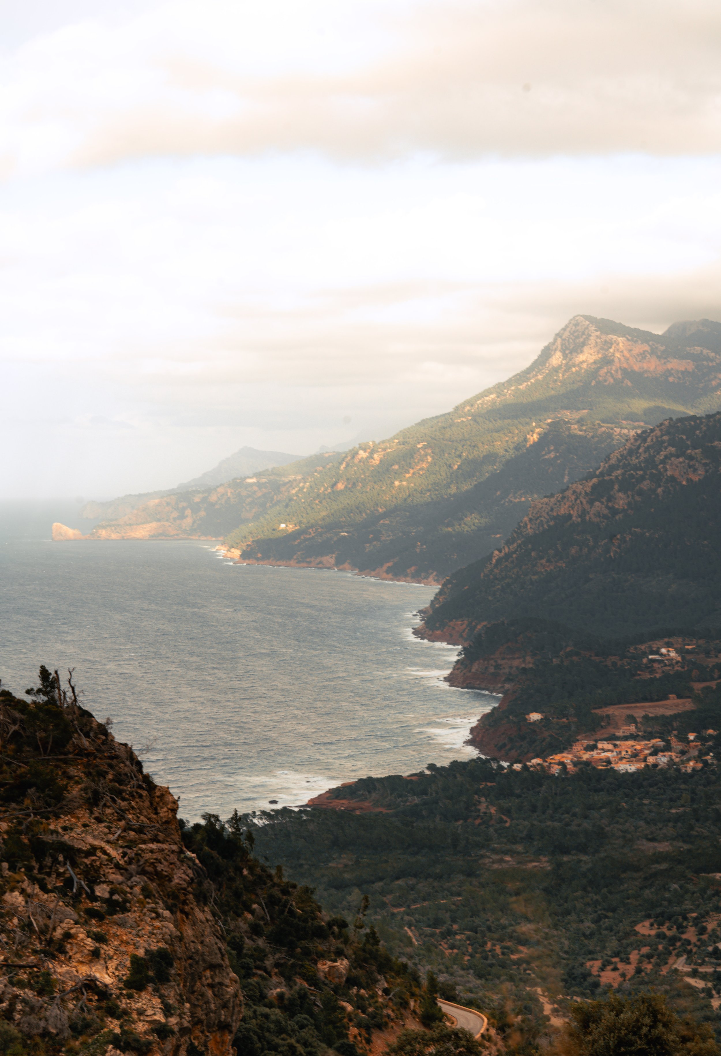 Scenic coastal landscape with mountains and the sea at sunset.