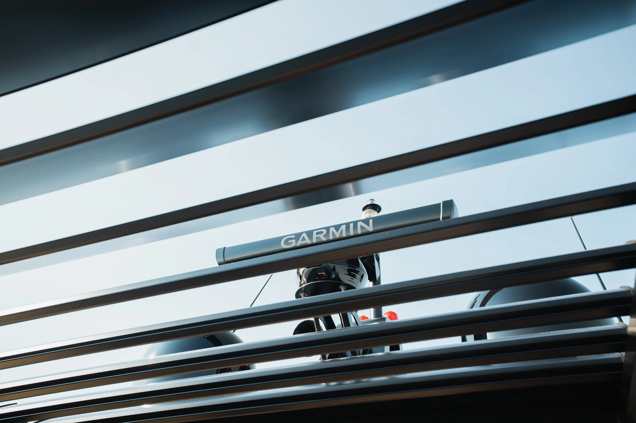A Garmin radar device mounted on a bicycle, viewed through horizontal metal bars.