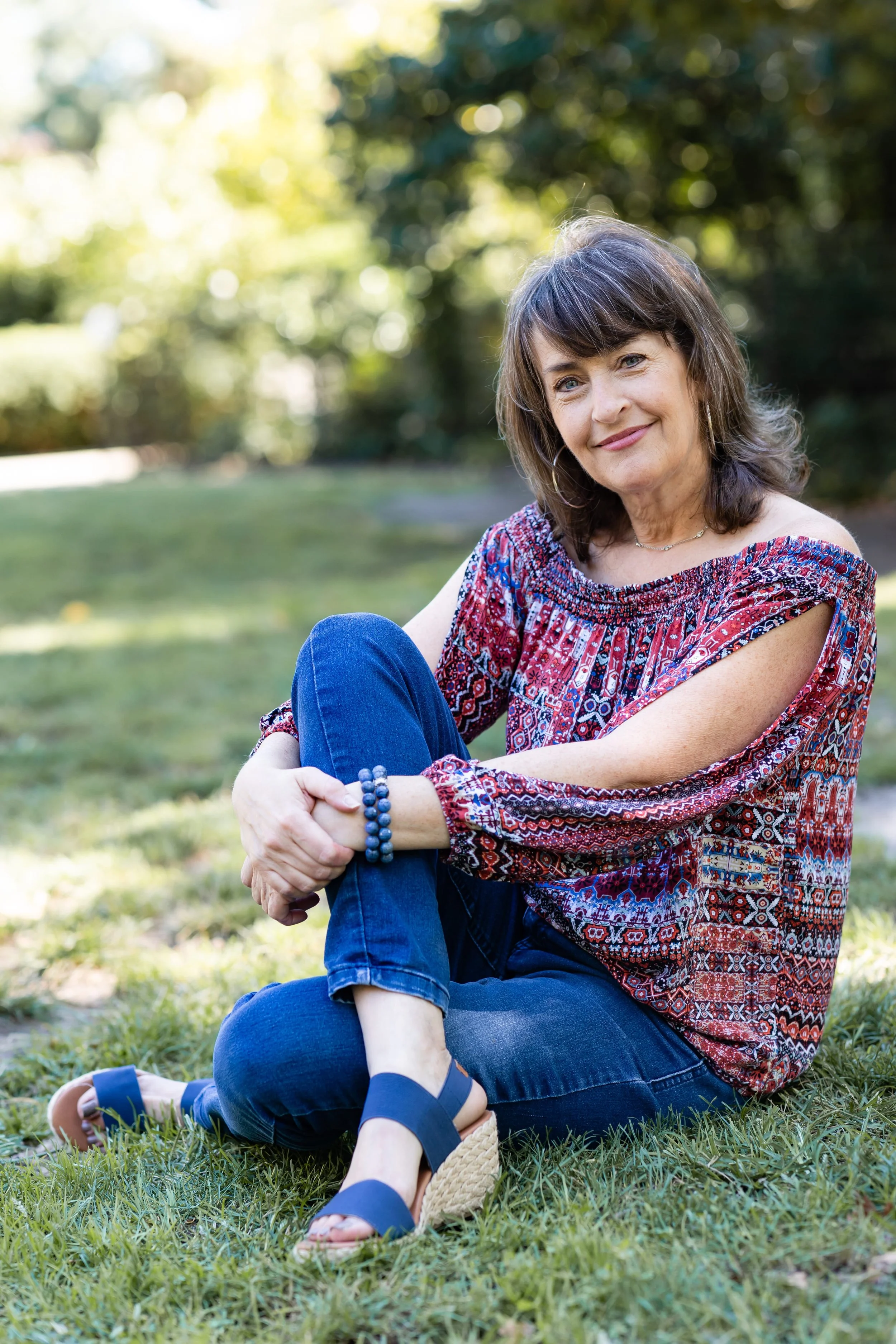 Relationship coach Sheira sitting on the grass.