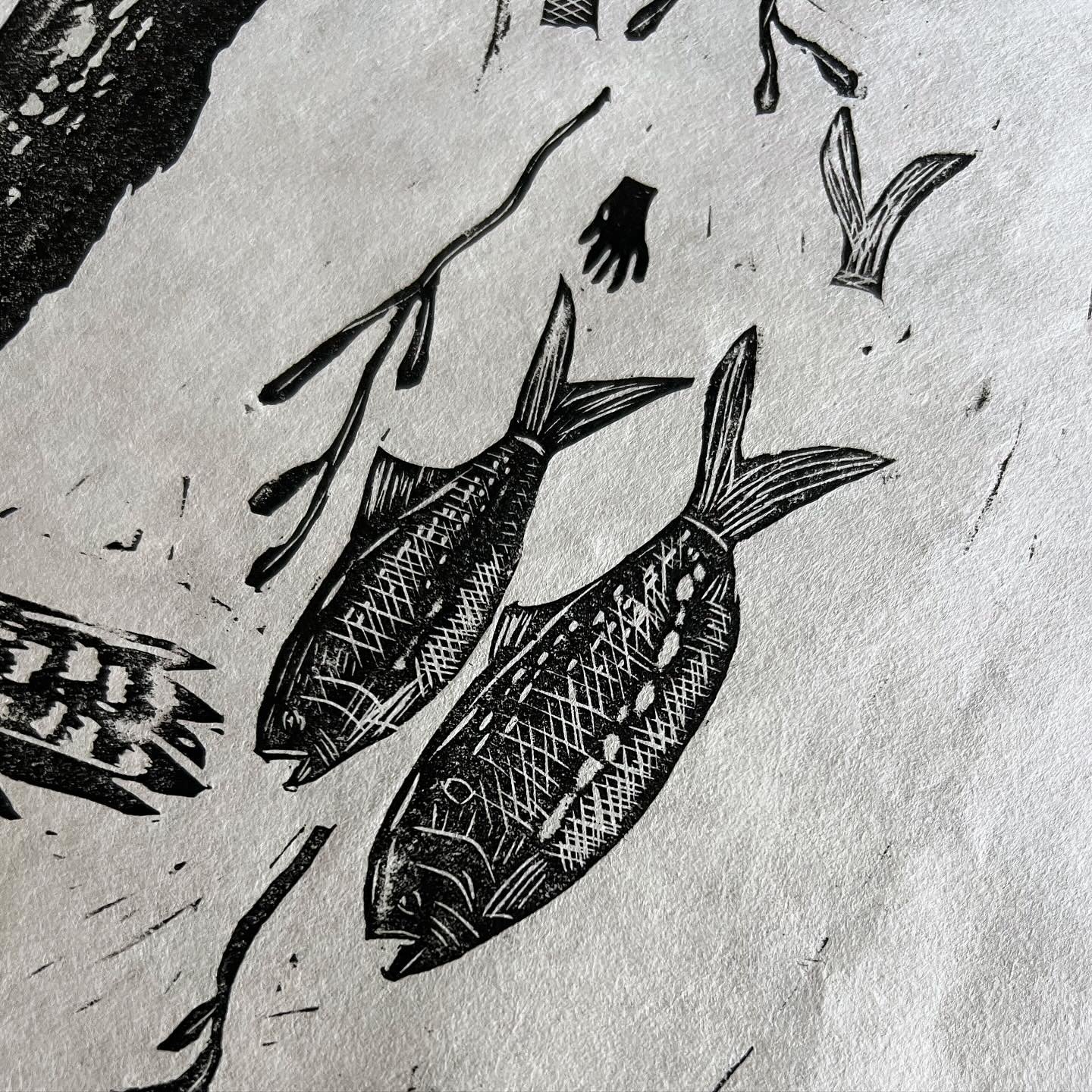 Two fish shown in linocut print