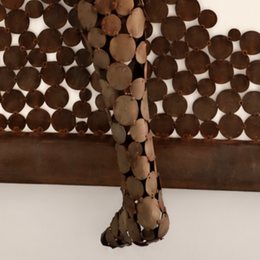 Sculpture murale abstraite en coquillages bruns formant une silhouette suspendue sur un fond blanc.