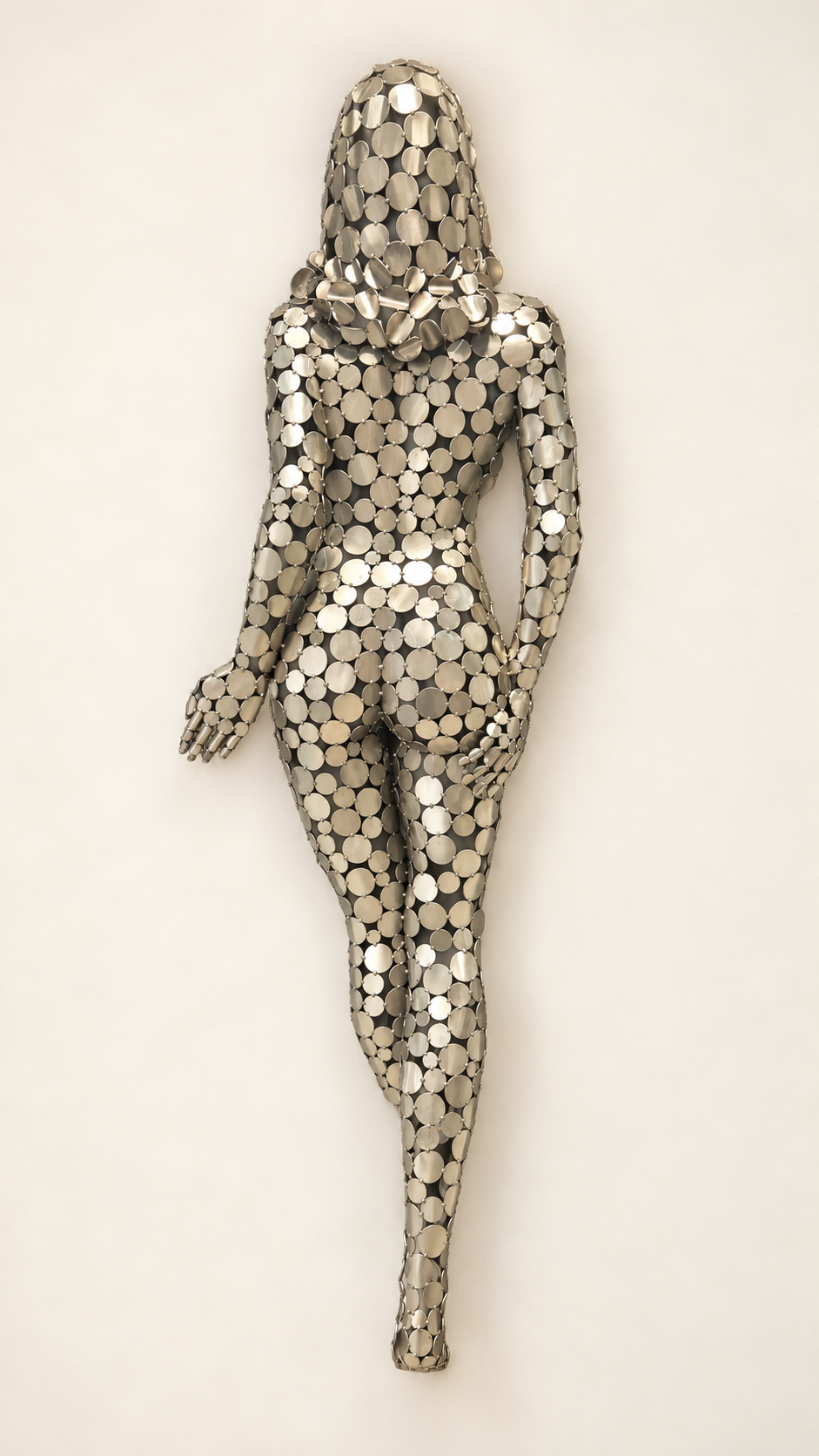 Sculpture murale d’un corps humain sans tête, réalisée avec des disques métalliques argentés.