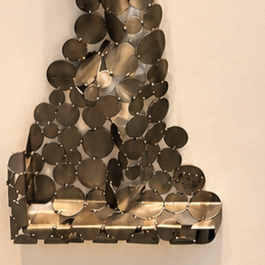 Sculpture murale abstraite en métal bronze composée de disques superposés