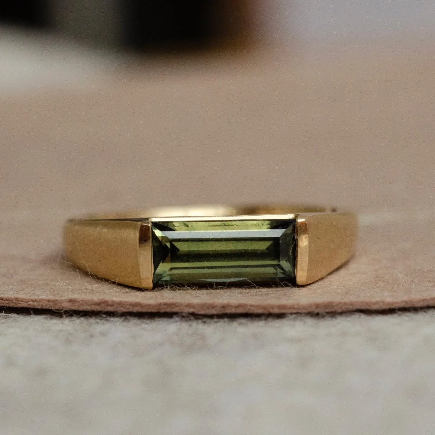 Available in my Commitment Shop! 
A minimalist&rsquo;s dream, this ring is all forest green and light coming through windows in the morning. A sleek, angular setting holds a deep green sapphire baguette with flashes of yellow and gold. Wear this on i