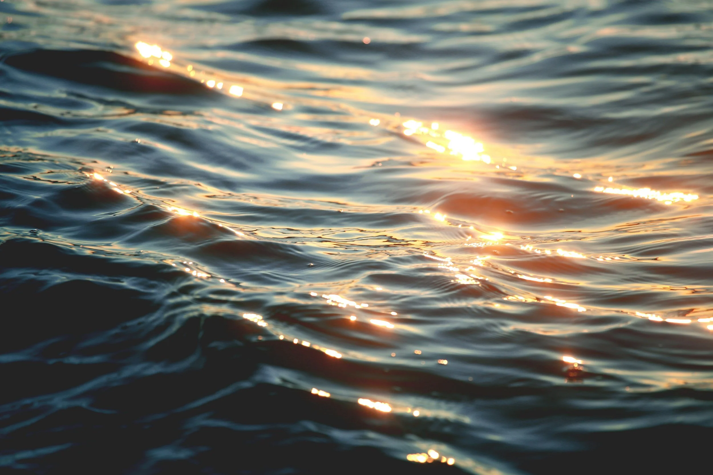 the sun glistens in the waves on the sea