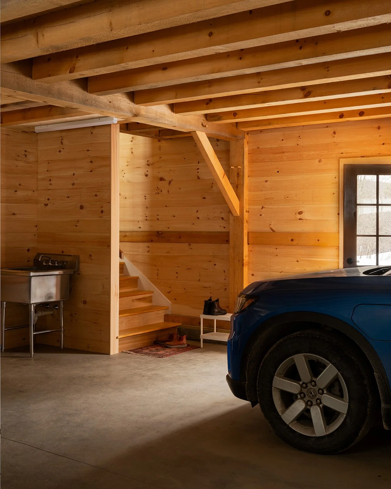 The stairs to the apartment above are near the entry door, which faces the main house. The garage comfortably fits two mid-size SUVs. The building was set up with enough voltage to allow for EV charging.