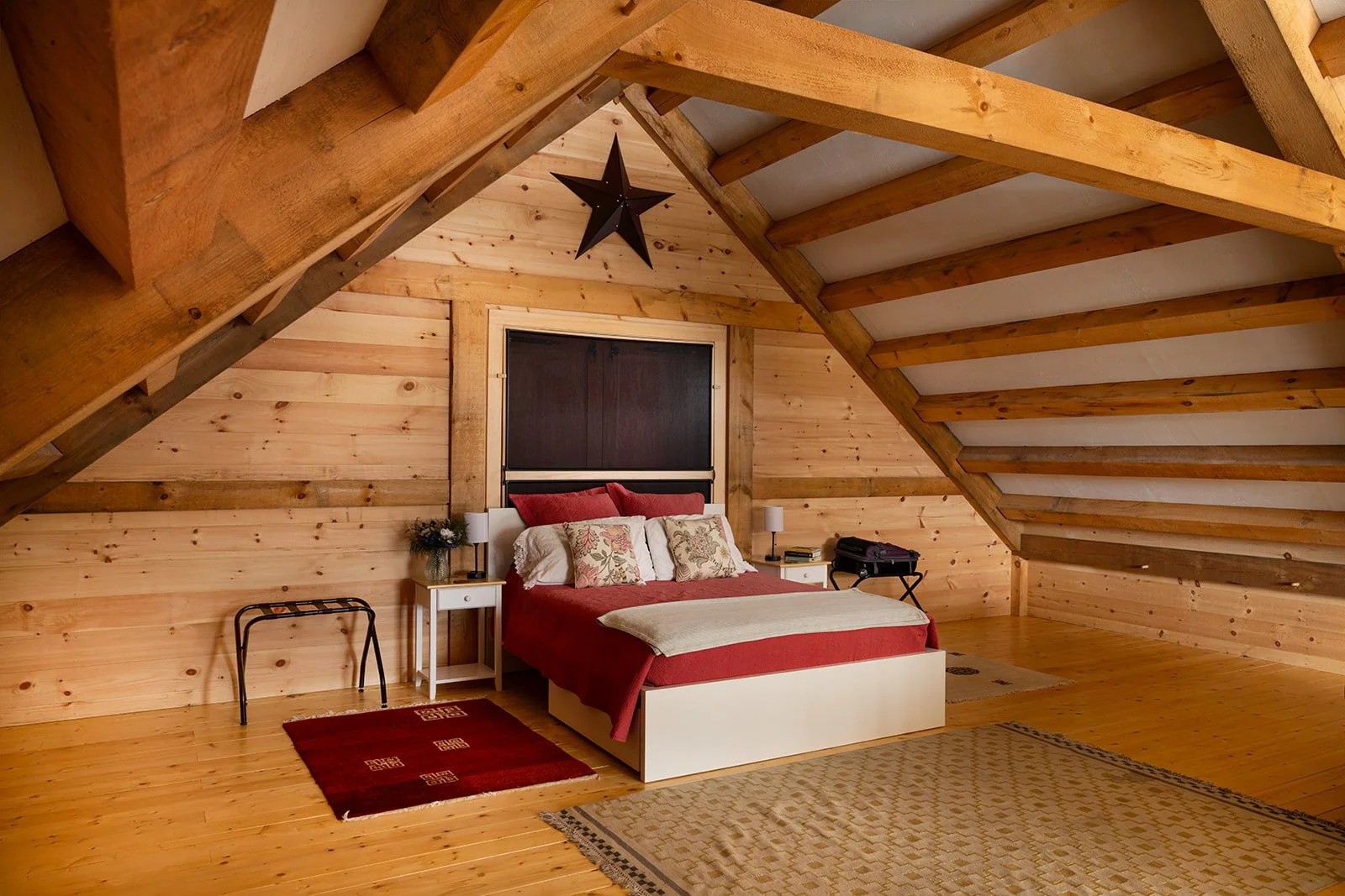 Behind the loft door, the guest bed faces the back of the building to allow guests to wake up to the Vermont countryside.