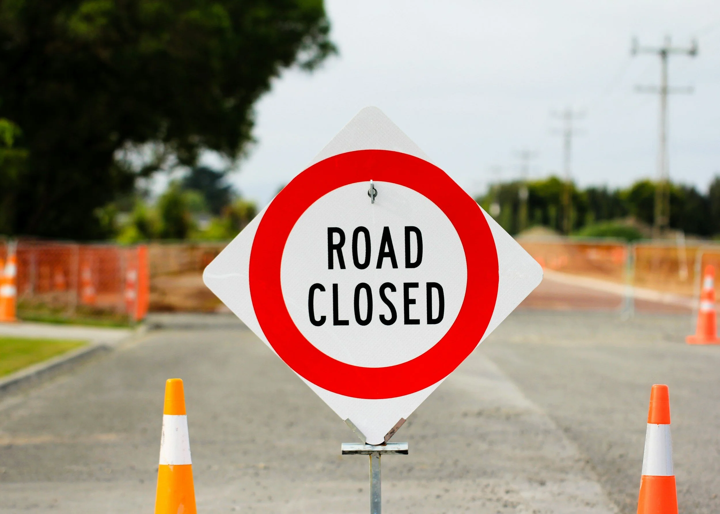 Road closed sign with construction cones.