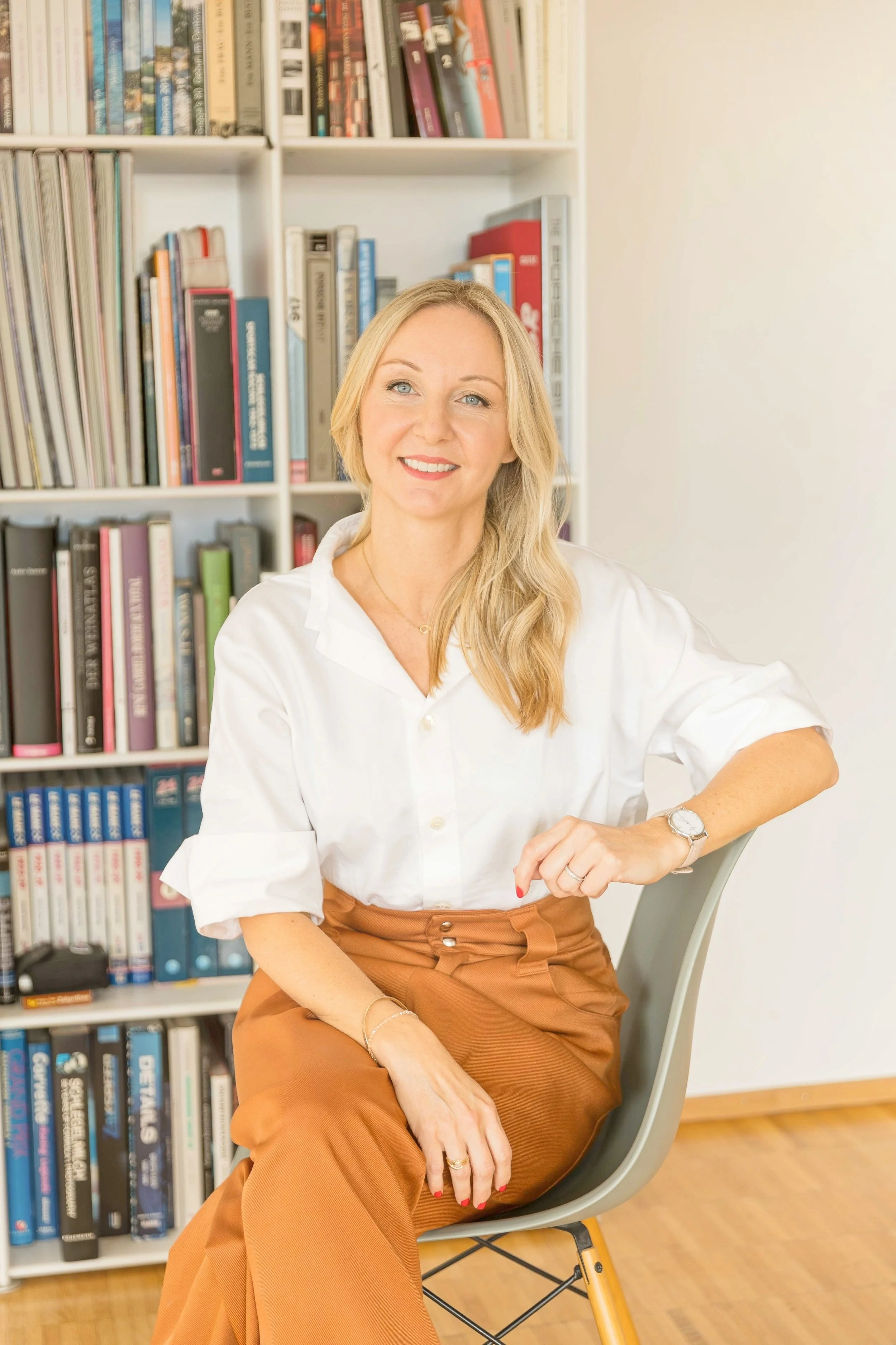 Coach Anna Schreier sitzt vor einem Bücherregal.jpg