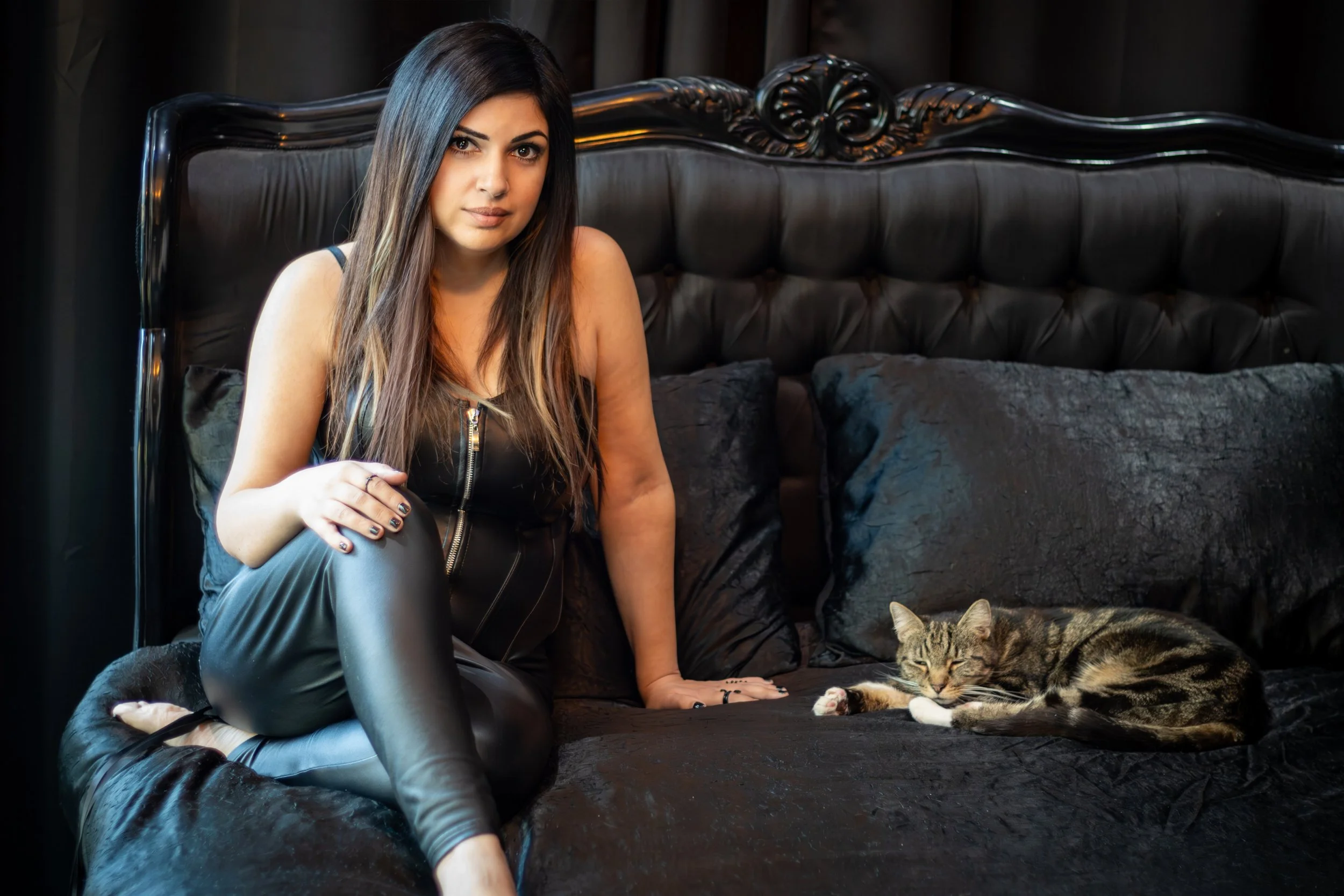 A photo of the pop singer Ariane X on a bed with a cat