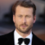 Man in a tuxedo with black bow tie, formal attire.