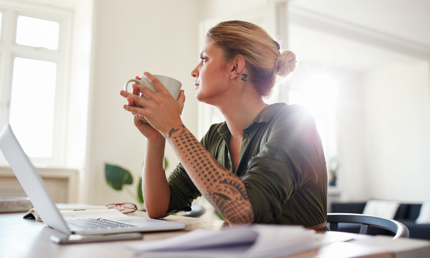 A woman sitting at a table looking contemplative