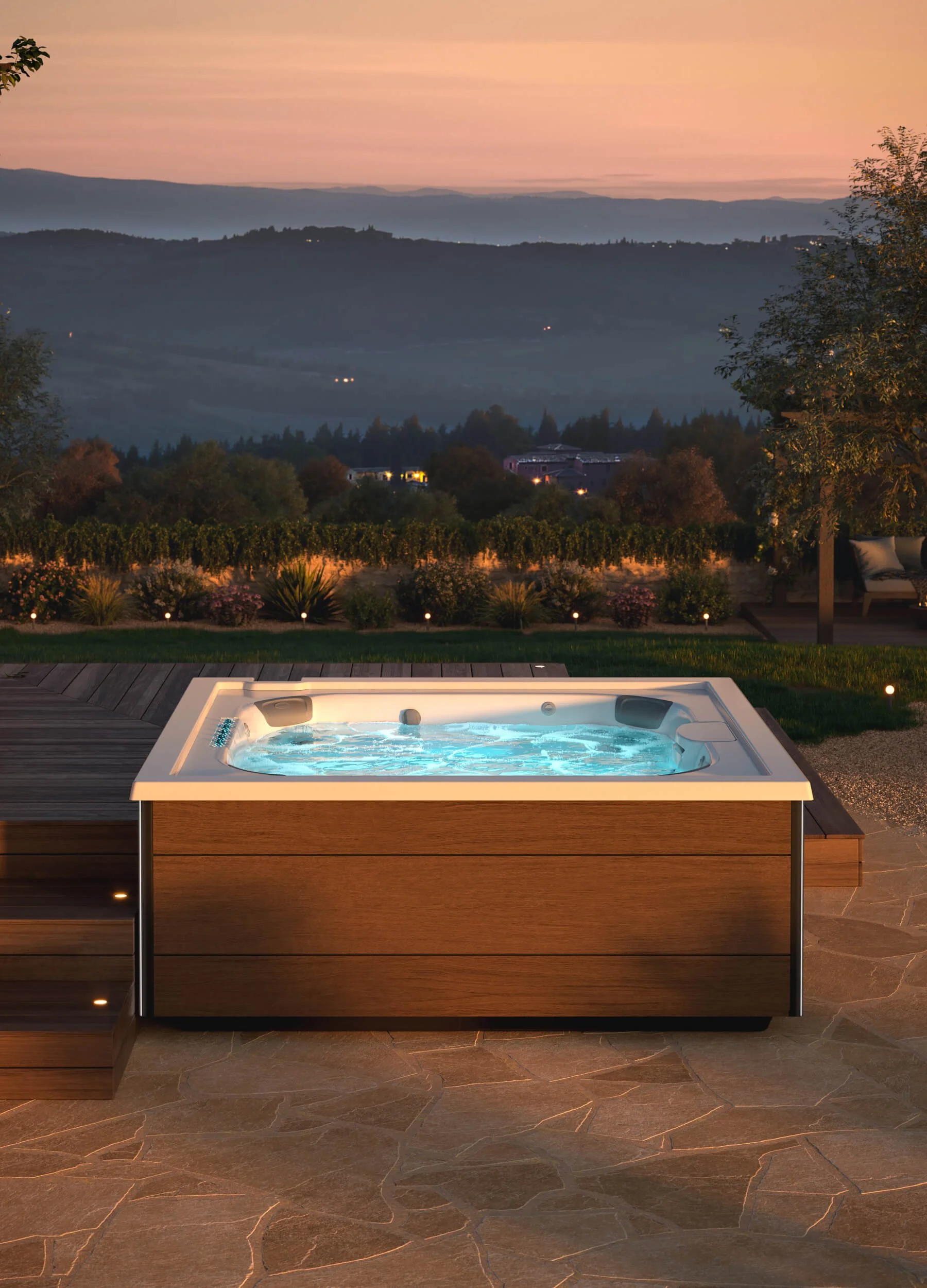 Product image - Jacuzzi® J408™ Hot Tub on stone/concrete patio overlooking pastoral views at dusk.