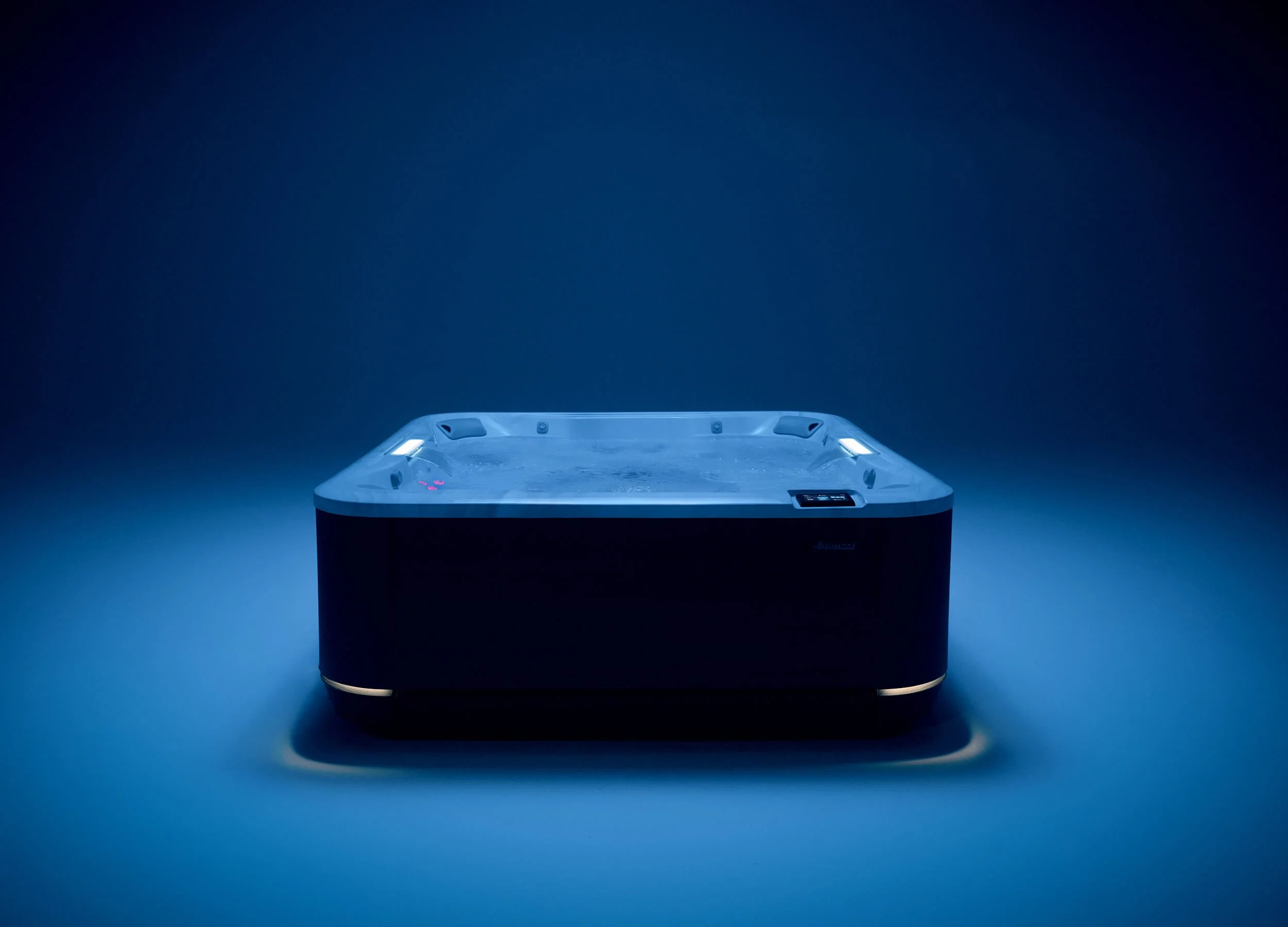 Jacuzzi® J509™ hot tub in a moody, blue interior setting.