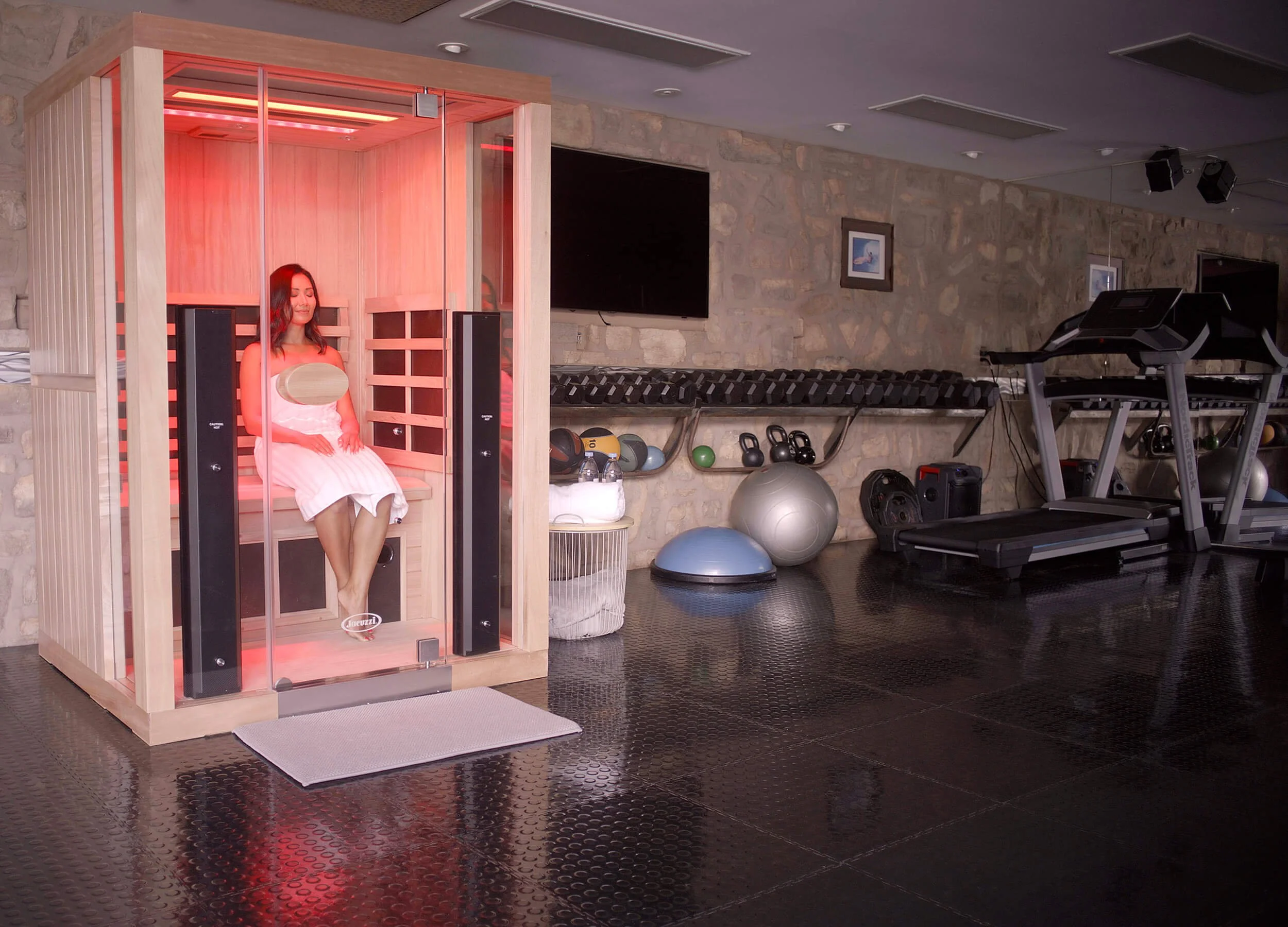 Image of woman sitting in sauna in a workout room